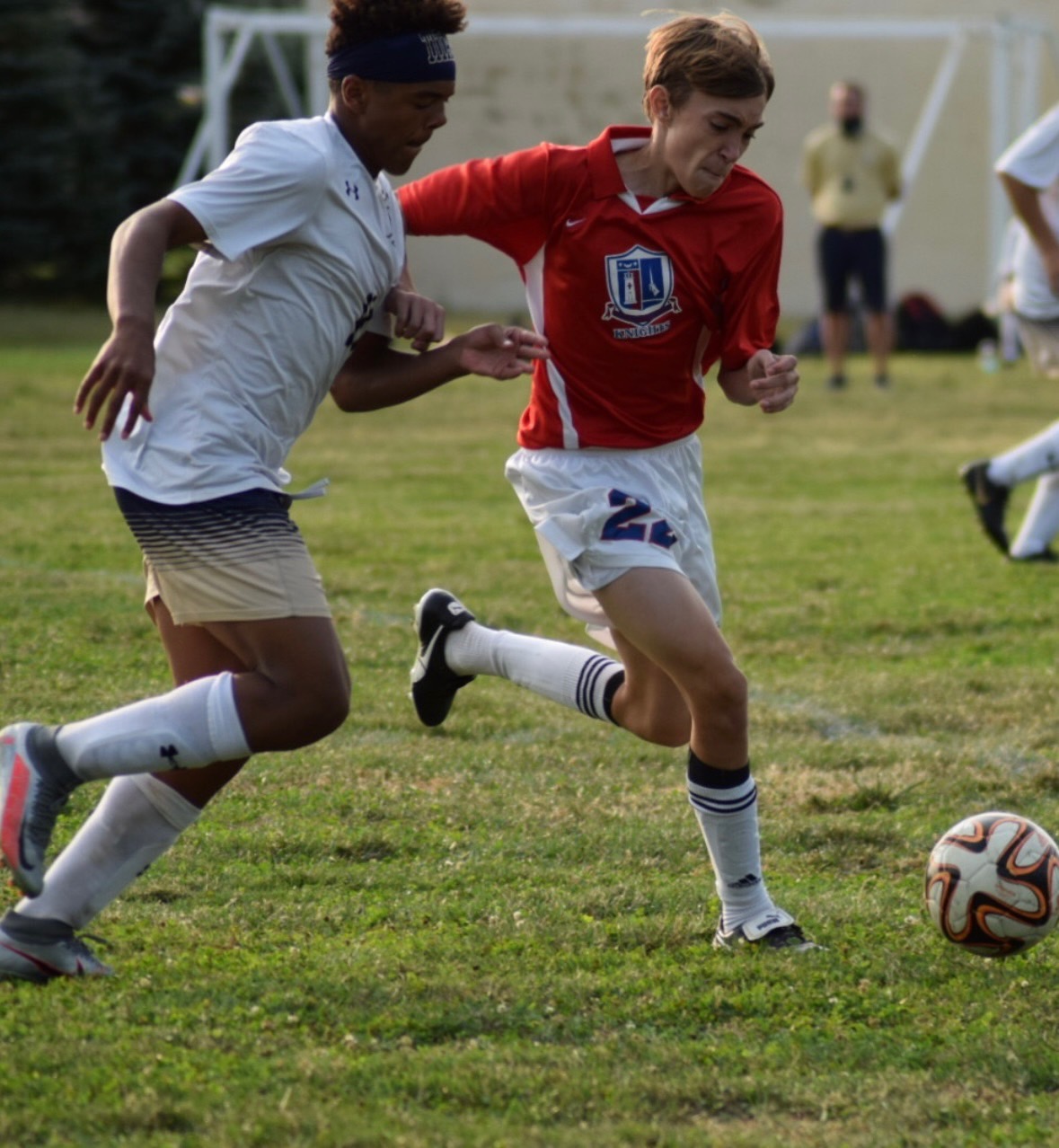 A band student playing soccer, about to kick the ball.